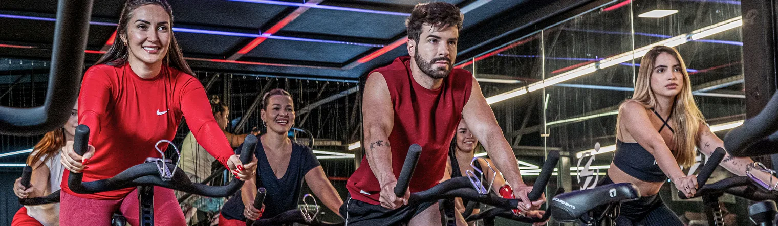 Alunos em aula de bike indoor numa unidade Corpo e Saúde